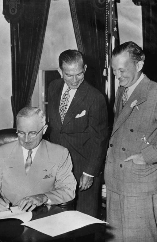 Photo of Harry Truman signing legislation