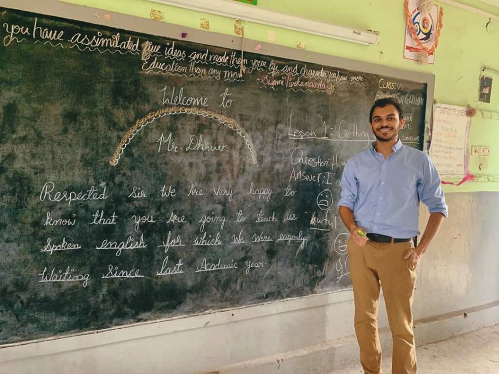Fulbrighter standing by a chalkboard, via Instagram.