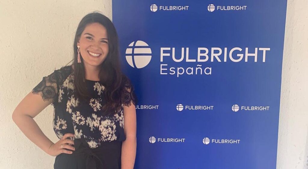 Woman standing in front of a "Fulbright España" sign.