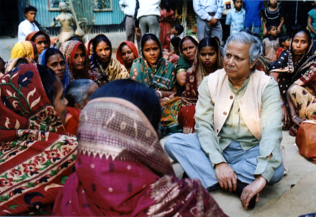 Muhammad Yunus sitting with a crowd of women