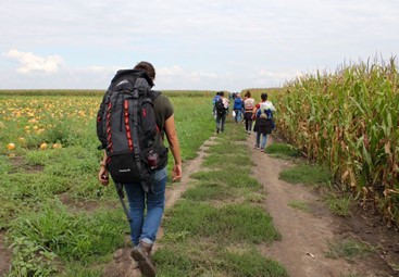 Hiba Dlewati (left) walks with a group of Syrian men, women, and children from war-torn Kobani as they trek to the Serbia-Hungary border after hours of walking in the baking sun.