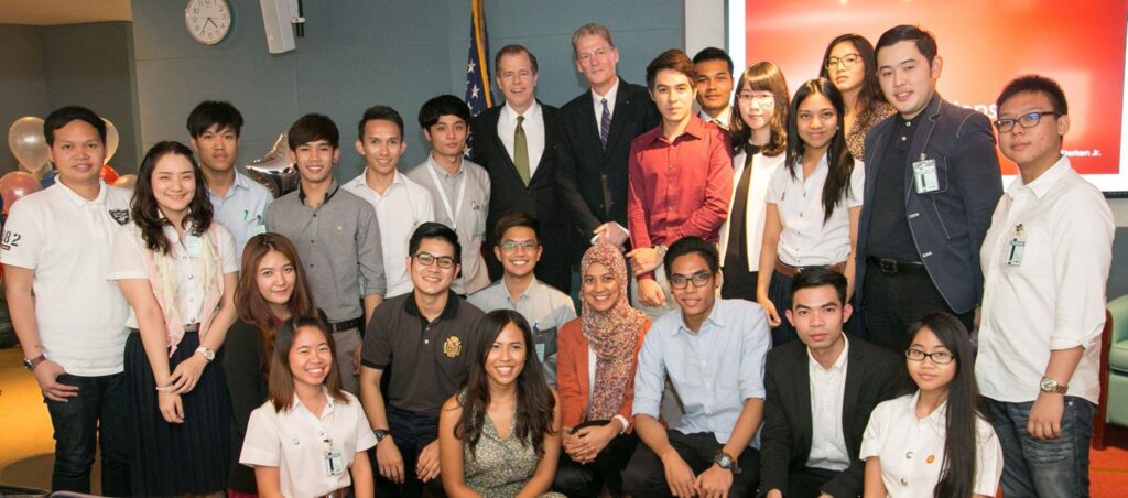 Dr. Robert Sterken, Fulbright Specialist and 2015 Fulbright U.S. Scholar to Burma, discusses democracy at the U.S. Embassy Thailand with Ambassador Glyn T. Davies in 2015. They stand together with a group of older students.