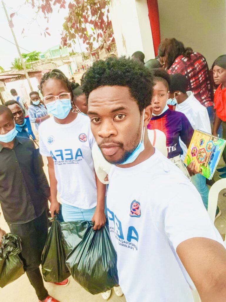 A man taking a selfie of himself and other volunteers at the Fulbright Day Angola community service event. Some people are wearing masks.