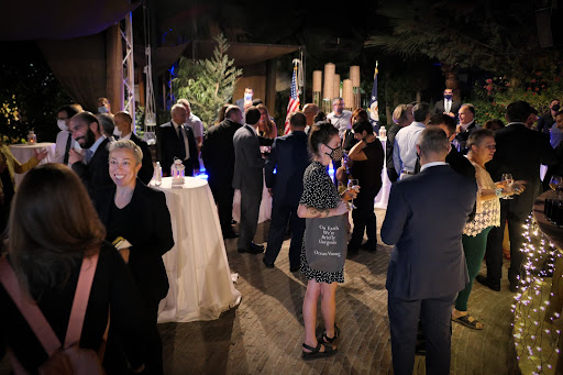A photo of guests at the in-person reception for Fulbright Day: Cyprus in business formal clothes. Some people are wearing masks.